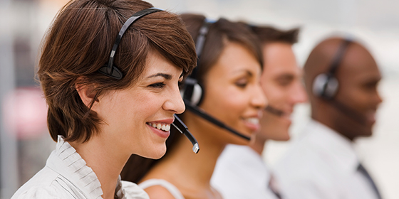 Customer support representatives wearing headsets in a call center.