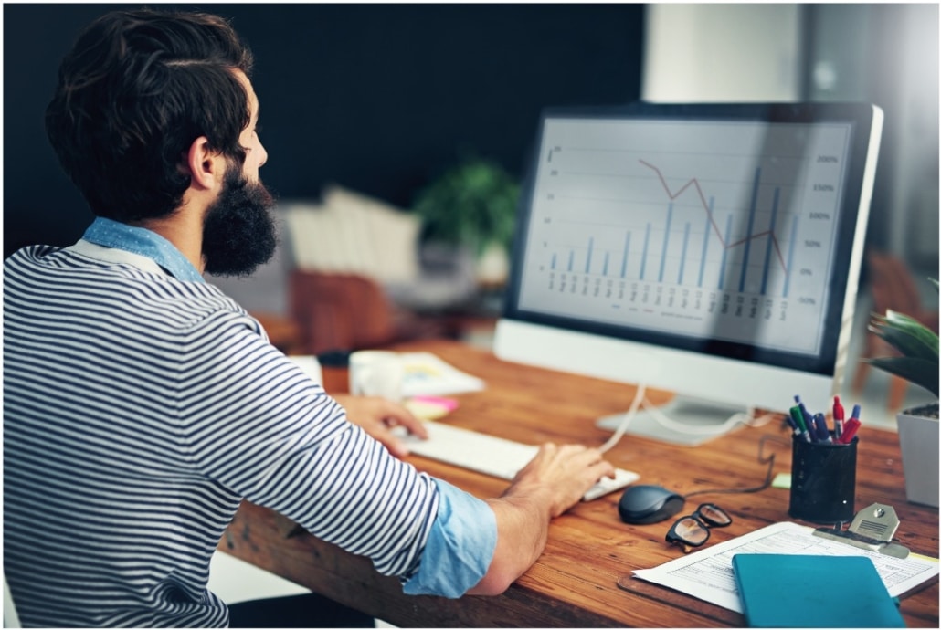 IT professional analyzing performance graphs on desktop computer in support of Splunk services.