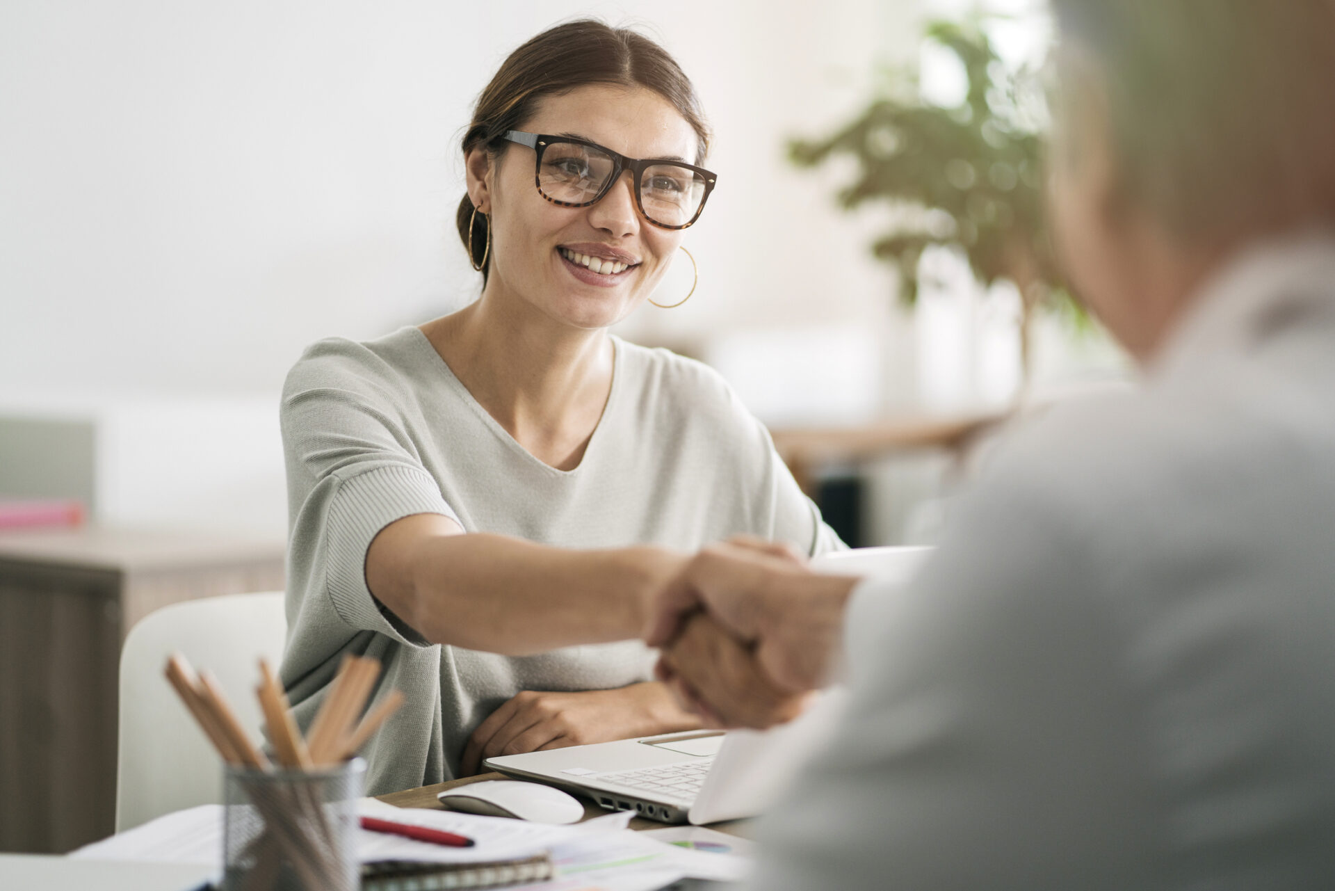 HR professional shaking hands with employee.