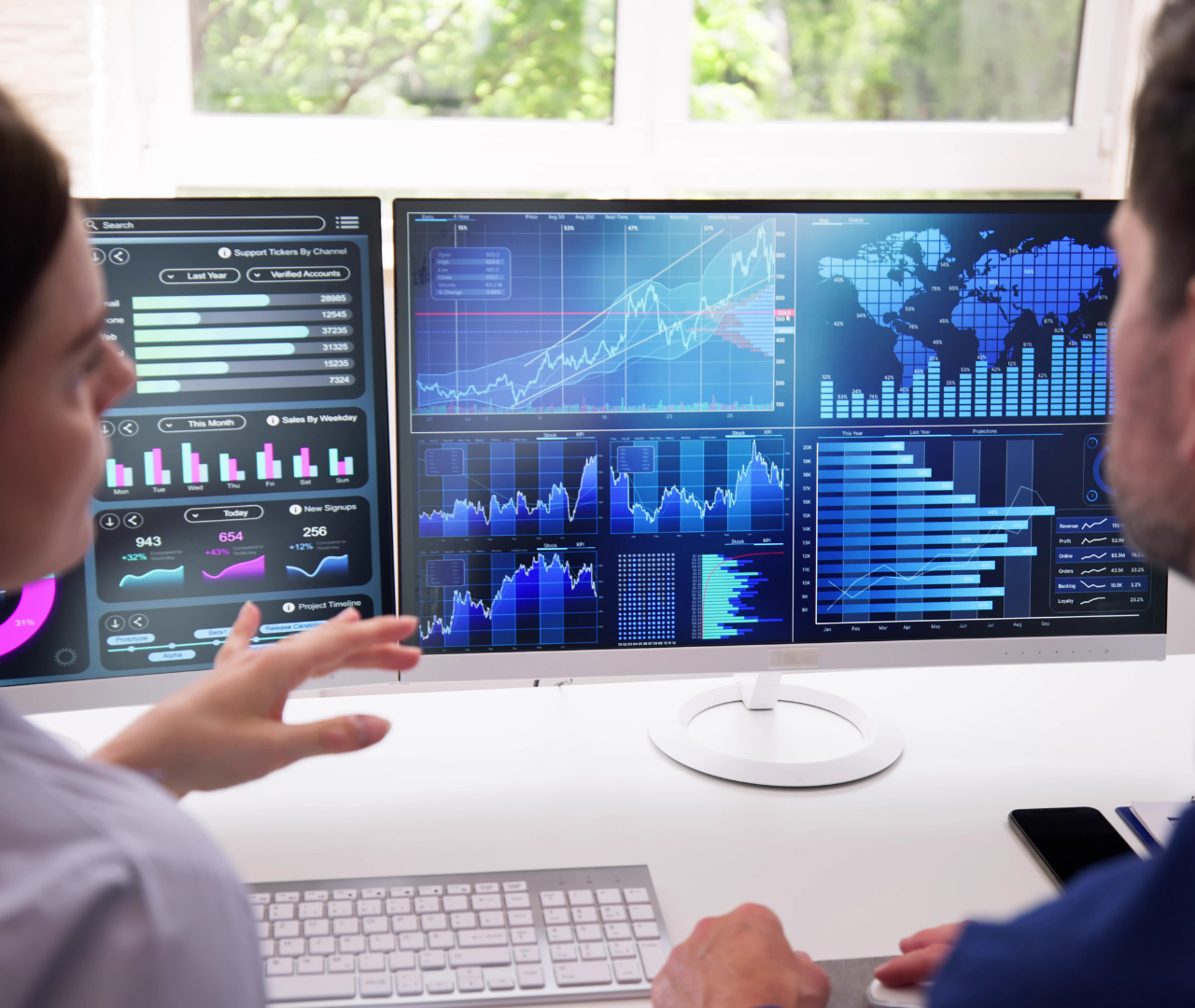 Business professionals reviewing cybersecurity portfolio performance metrics on data dashboards.