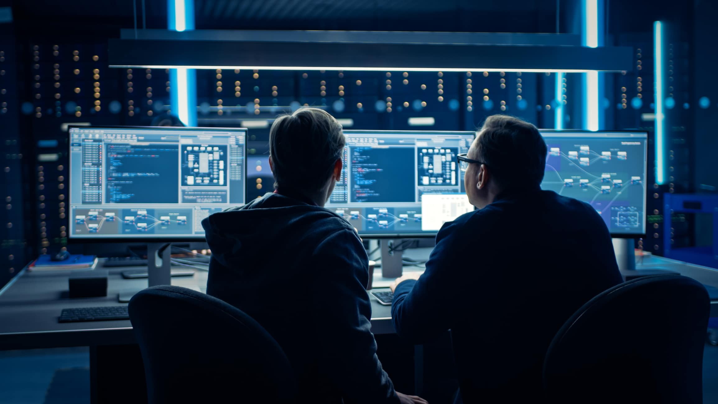IT professionals monitoring cybersecurity dashboards in a control room.