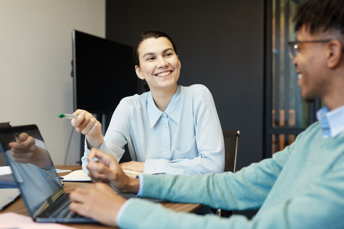 Female and male colleague brainstorming security solutions in conference room.