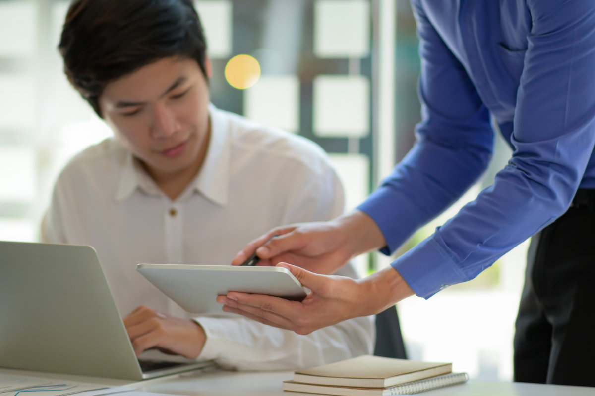 Colleague sharing security data on a table with another security colleague in an office environment.