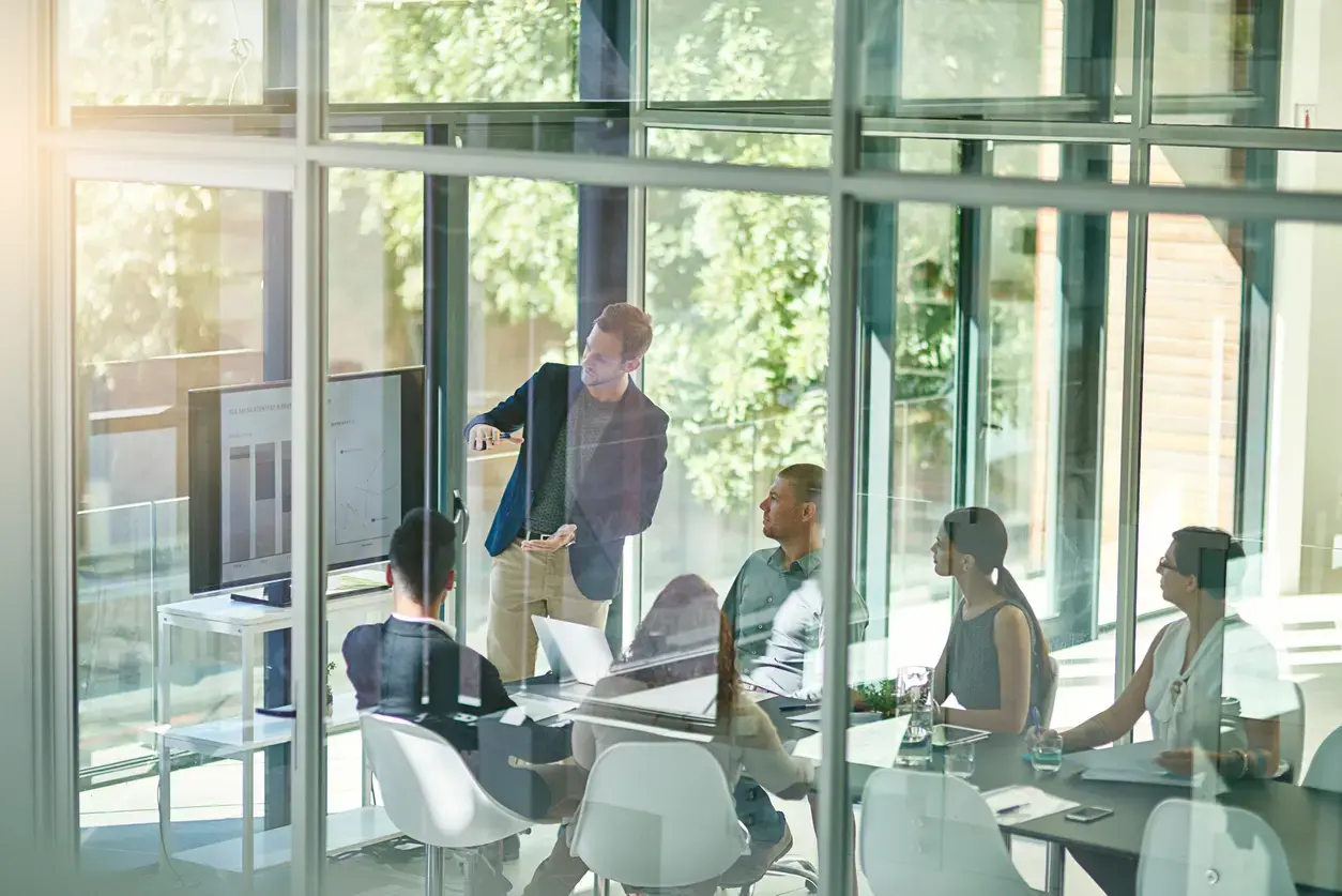 Business professionals in a modern glass conference room during a strategic consulting meeting.