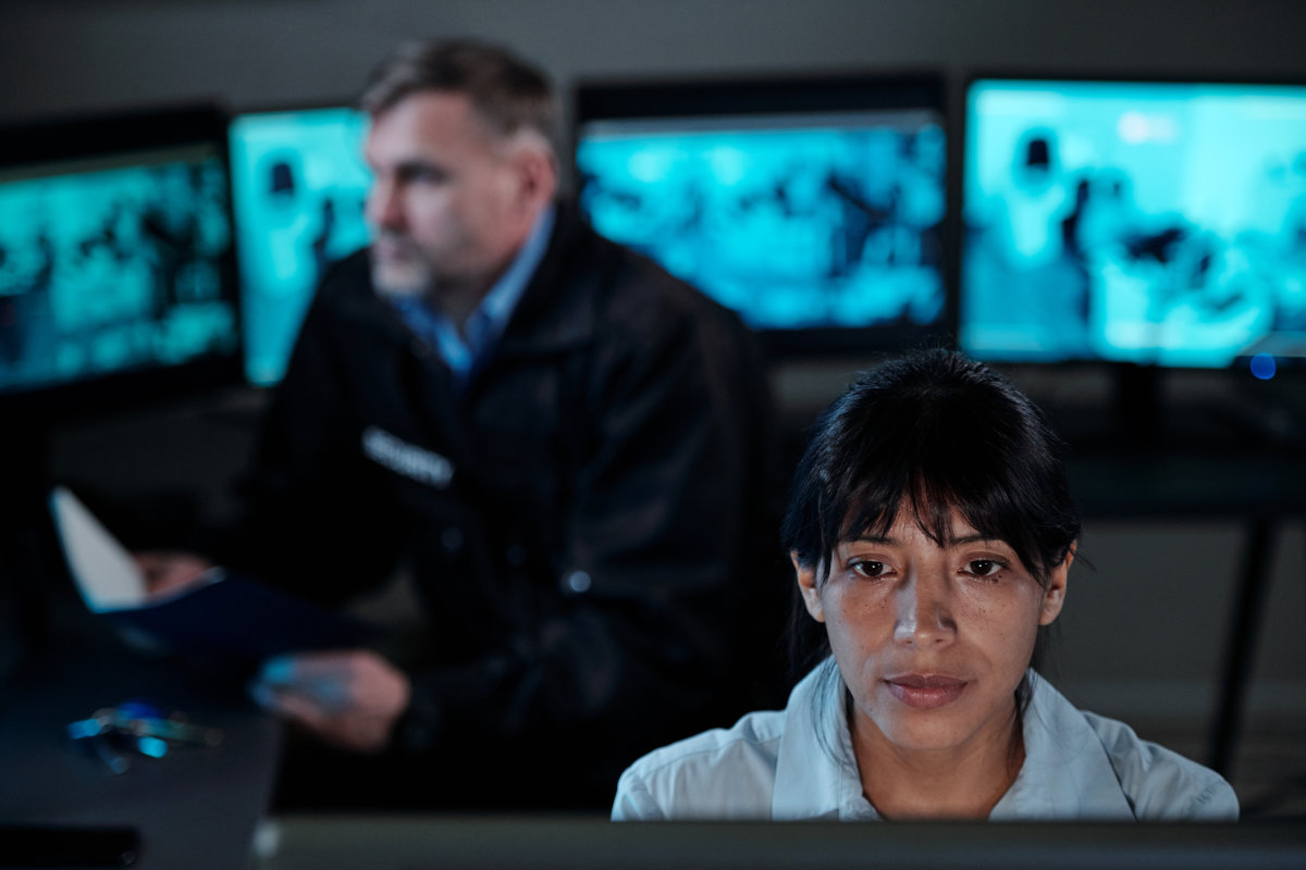 Cybersecurity analyst monitoring multiple data screens in a security operations center.